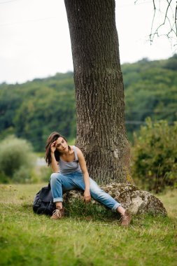 büyük bir taş üzerinde oturan kız