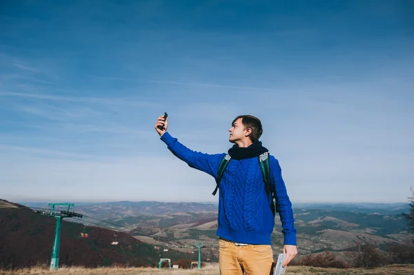 Joven hipster tomando fotos en la montaña — Foto de Stock