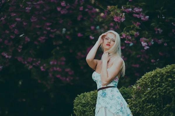 Prachtige blond meisje in tuin — Stockfoto