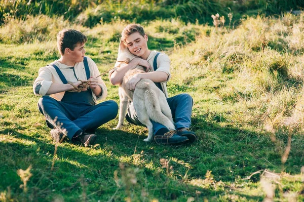 Dois irmãos gêmeos com cão husky — Fotografia de Stock