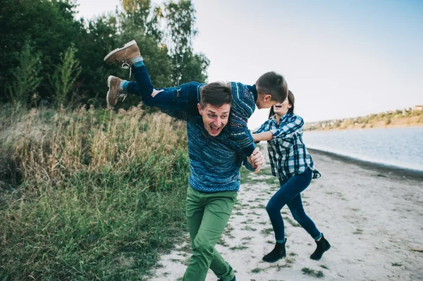 Familia joven posando cerca del lago — Foto de Stock