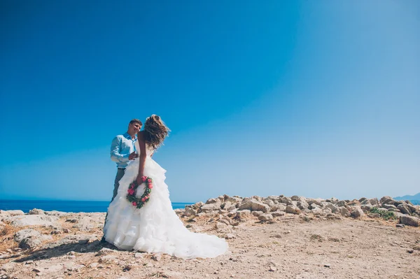 Blonde Braut und stilvoller Bräutigam auf Felsen — Stockfoto