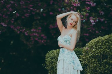 Çiçek bahçesinde sarışın kız