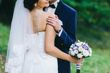 Düğün çifti el ele tutuşuyor.