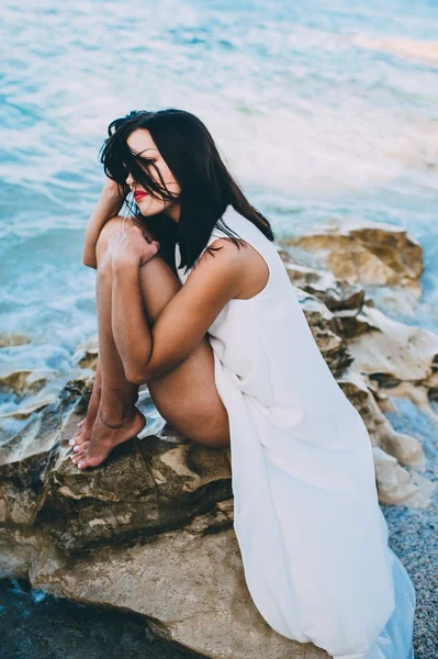 Schönes Mädchen sitzt auf einem Felsen — Stockfoto