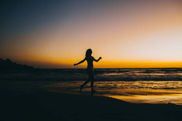 Силуэт девушки с морского пляжа — стоковое фото
