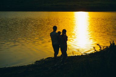 gün batımında küçük çocukları ile anne