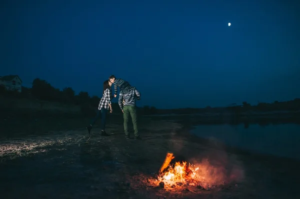 Kamp ateşi etrafında oturan aile — Stok fotoğraf