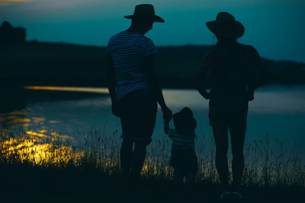 Parents with their little child at sunset — Stock Photo, Image