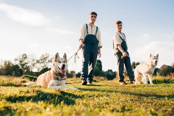 Twins take a walk with the dogs — Stock Photo, Image