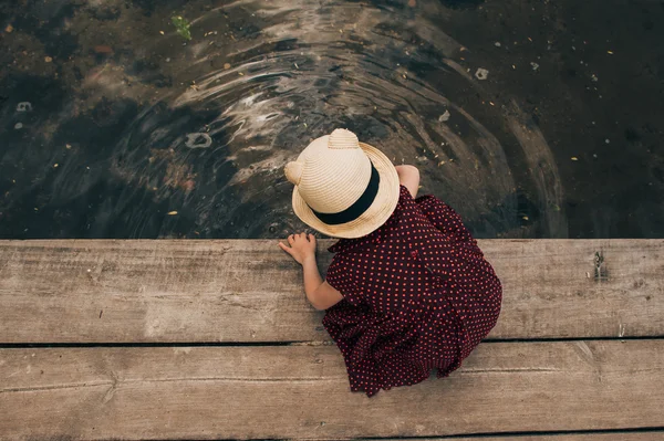 Osamělý holčičky sedící na molu — Stock fotografie