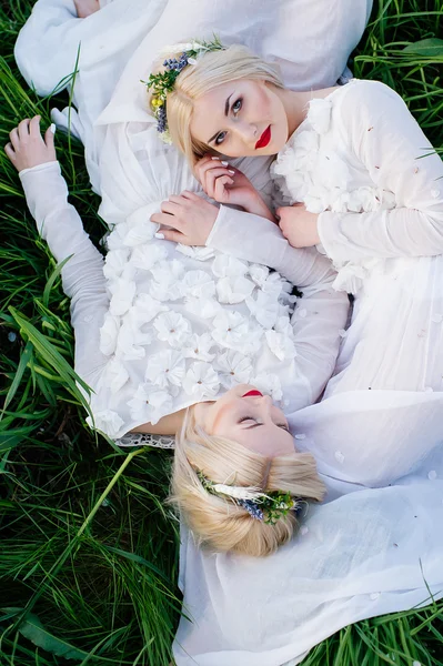 Близнецы лежат на зеленой траве — стоковое фото