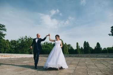 Düğün çifti el ele tutuşuyor.