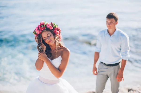 Bruid en bruidegom door de zee — Stockfoto