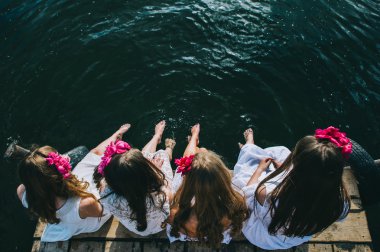 Bir jet üzerinde oturan dört genç kız  