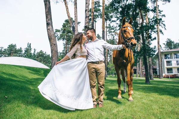 Casal de pé ao lado de um cavalo — Fotografia de Stock
