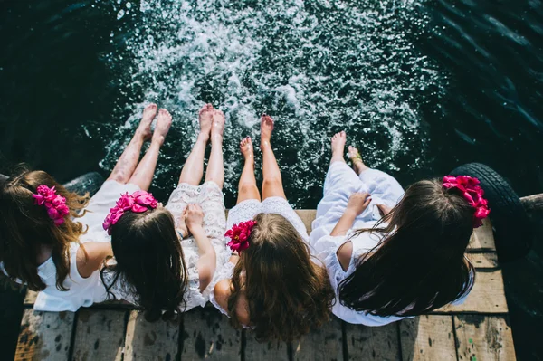 Чотири молоді дівчата сидять на струмені — стокове фото