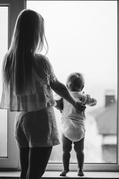 Mutter mit Baby sitzt am Fenster — Stockfoto