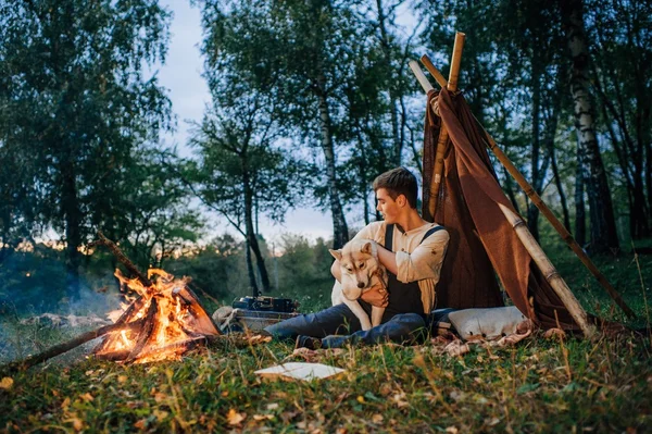 Τύπος που κάθεται γύρω από ένα campfire — Φωτογραφία Αρχείου