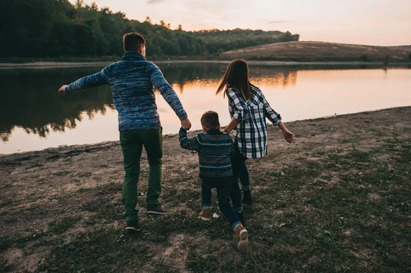 Jeune famille en promenade au bord du lac — Photo