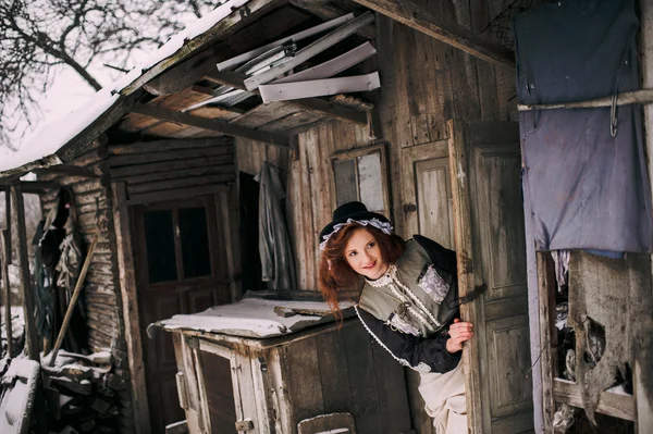 Femme portant un tissu rétro près de la vieille maison — Photo