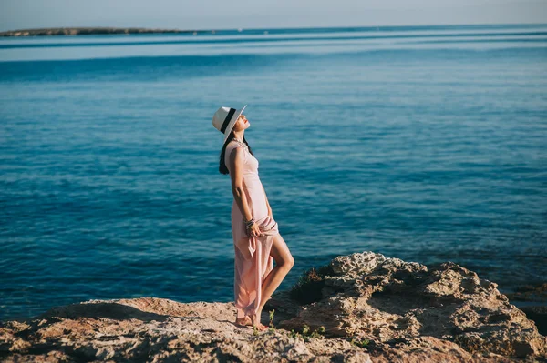 Belle fille debout sur le bord de mer rocheux — Photo