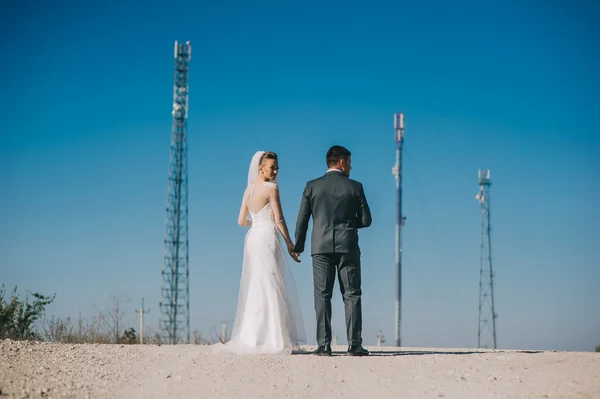 Recién casados posando en la carretera — Foto de Stock