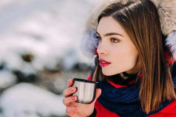 Дівчина п'є з термос зими — стокове фото