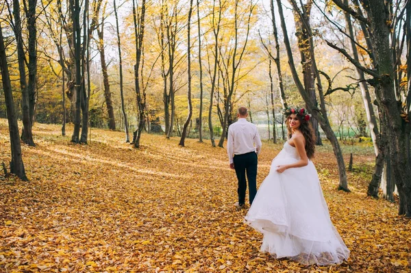 Les jeunes mariés marchent dans la forêt d'automne — Photo