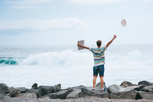 Человек с ноутбуком на берегу моря — стоковое фото