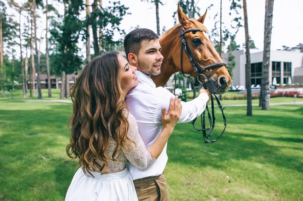 Jeunes mariés debout à côté d'un cheval — Photo