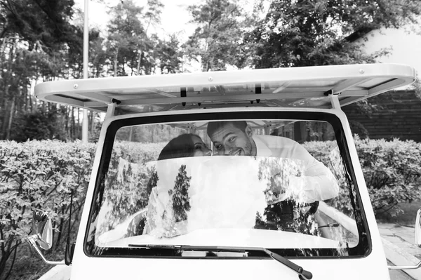 Bride and groom driving a golf cart — Stock Photo, Image