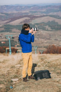 Bir uçurumun kenarında bir kamera ile adam  