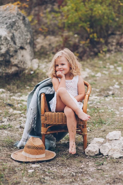 Menina em uma cadeira ao ar livre — Fotografia de Stock