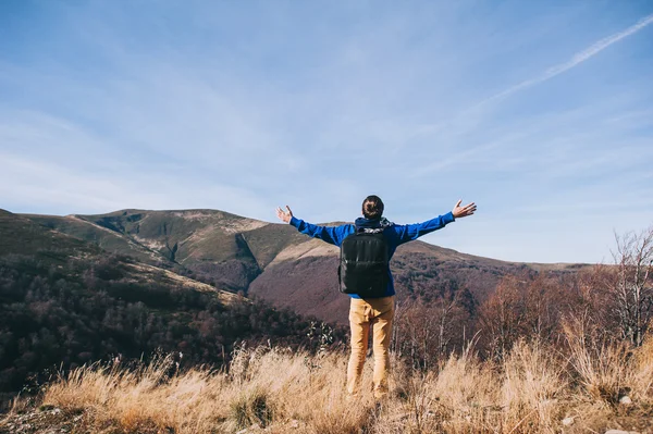 Beau jeune homme debout sur un rocher — Photo