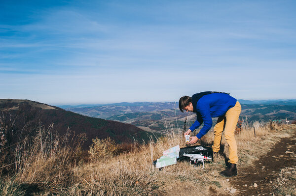 мужчина держит дрон для аэрофотосъемки
