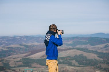 Bir uçurumun kenarında bir kamera ile adam  