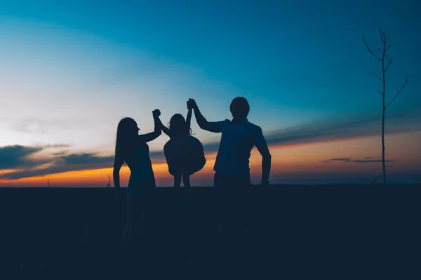 Feliz família juntos ao pôr do sol — Fotografia de Stock