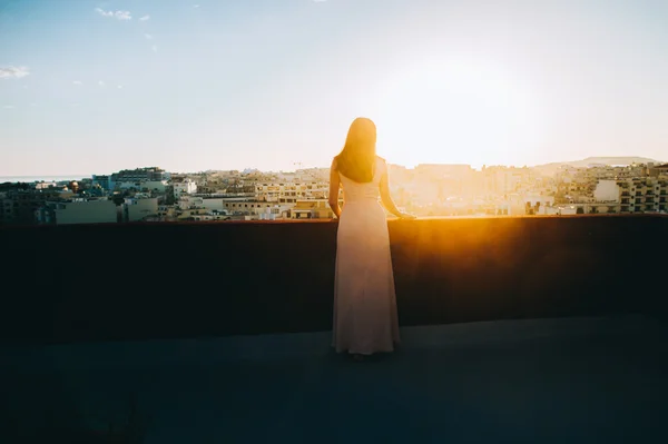 Mujer en vestido de noche contra el paisaje urbano — Foto de Stock