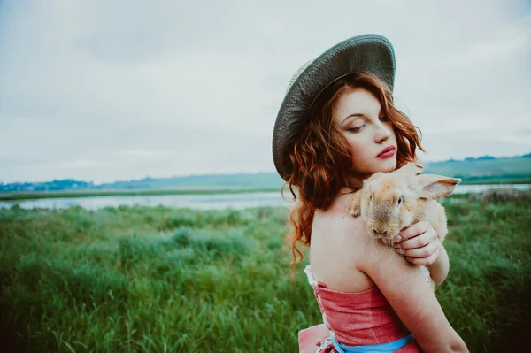 Ragazza con un coniglio all'aperto — Foto Stock