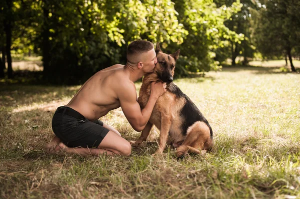 Athletic guy with a German Shepherd — Stock Photo, Image