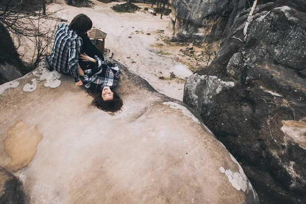 Jovem casal sentado na rocha — Fotografia de Stock