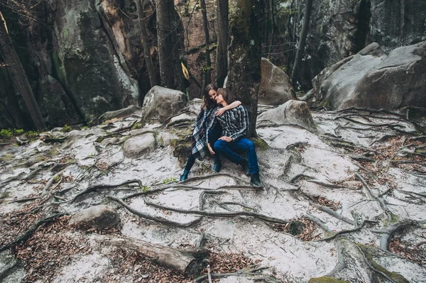 Joven pareja sentado en roca — Foto de Stock