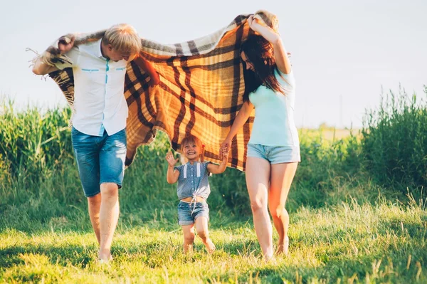 Familjen som körs i äng — Stockfoto