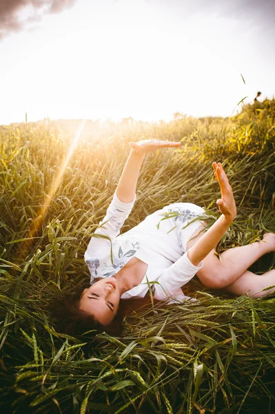 Menina deitada em trigo — Fotografia de Stock