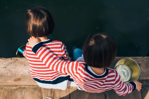 Hermanas gemelas en muelle de madera —  Fotos de Stock