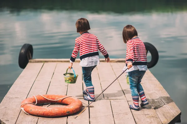 Twin sisters on wooden pier — Stock Photo, Image