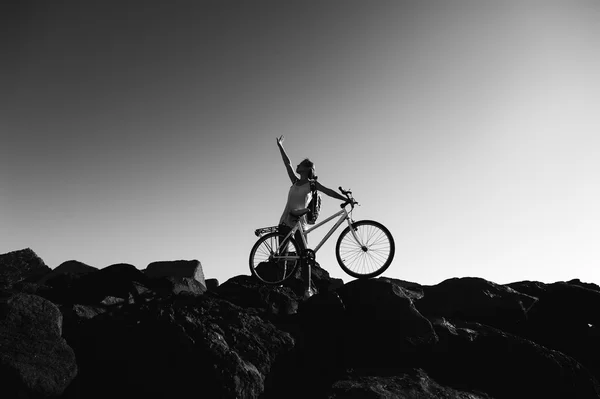 Mulher com bicicleta em pé na costa — Fotografia de Stock