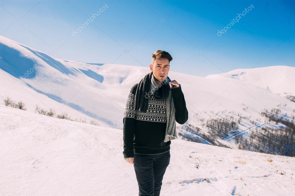 young man posing in snowy mountains