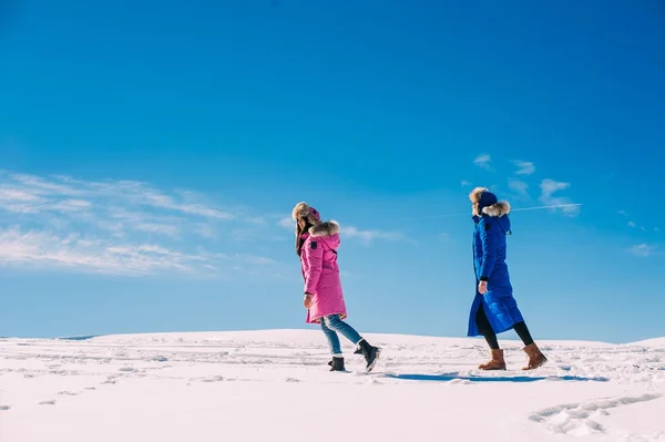 Mujeres caminando en montañas nevadas — Foto de Stock